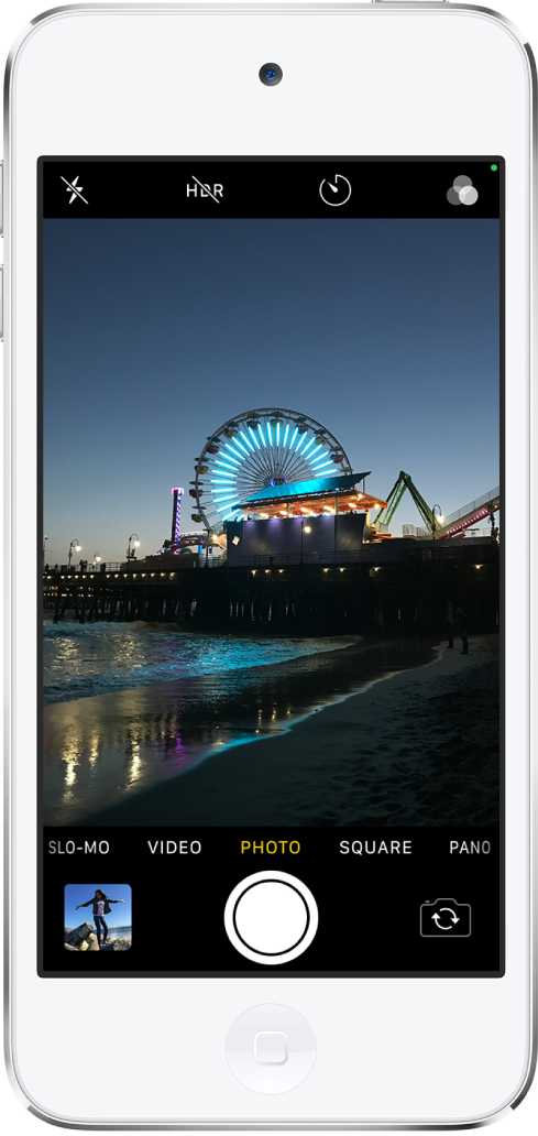 L’appareil photo en mode Photo, avec les autres modes à gauche et à droite sous le visualiseur. Les boutons pour le flash, le mode HDR, le retardateur et les filtres apparaissent en haut de l’écran. Le bouton du visualiseur de photos et de vidéos se trouve dans le coin inférieur gauche. Le bouton « Prendre une photo » se trouve en bas au centre et le bouton « Sélecteur de caméra - face arrière » est dans le coin inférieur droit.