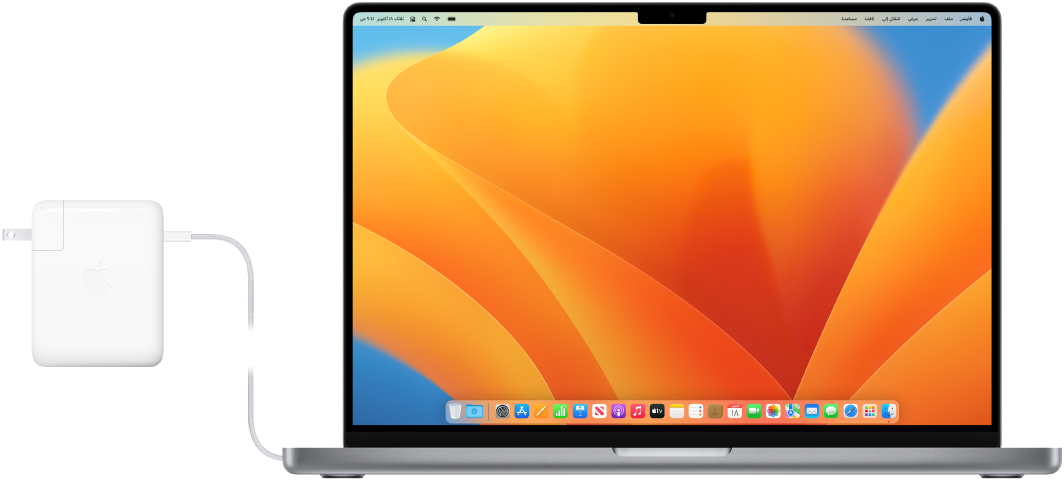 MacBook Pro مقاس 16 بوصة موصول بمحول الطاقة.
