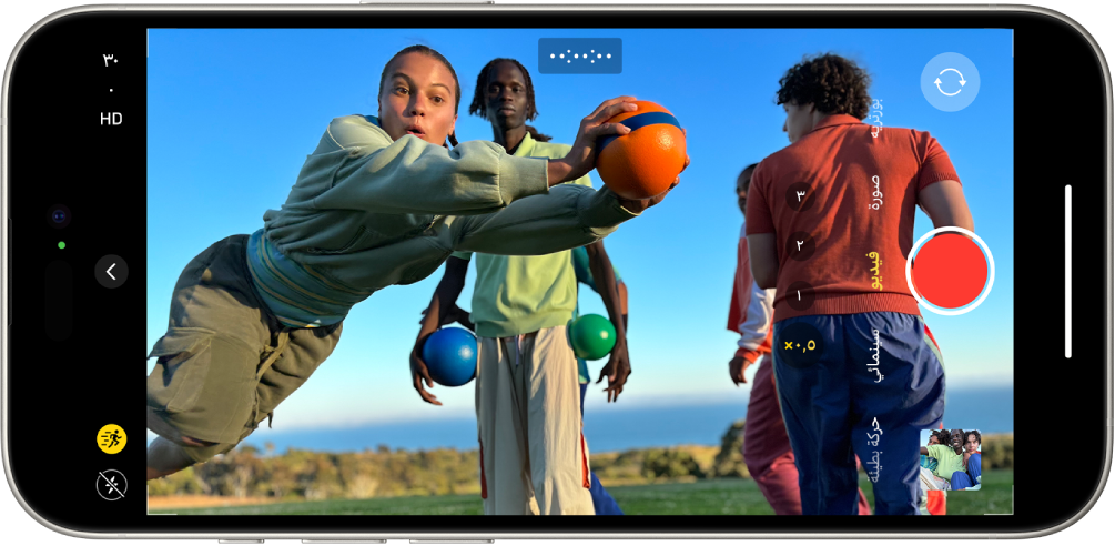 iPhone مقلوب في اتجاه أفقي. تطبيق الكاميرا مفتوح على نمط الفيديو. في إطار الكاميرا، يوجد شخص يركض. يوجد زر الفلاش في الزاوية السفلية اليمنى من الشاشة. يوجد زر عناصر التحكم في الكاميرا في منتصف الجانب الأيمن من الشاشة. يوجد في الزاوية العلوية اليمنى مفاتيح تبديل سريعة لتبديل دقة الفيديو ومعدل الإطارات. زر الحركة الموجود في الزاوية العلوية اليمنى قيد التشغيل. يظهر على الجانب الأيسر، من الجزء العلوي إلى الجزء السفلي، زر اختيار الكاميرا - الخلفية، وزر التسجيل، وزر عارض الصور والفيديو. في عارض اللقطة، يظهر شخص ما يركض.