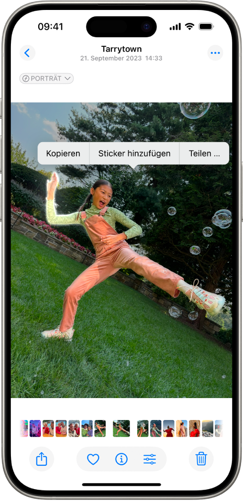 In der App „Fotos“ ist das Foto einer Person geöffnet. Die Person ist ausgewählt und die Option „Sticker hinzufügen“ ist in dem Menü darüber verfügbar.